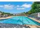 Community pool featuring a large pool, lounge chairs, umbrellas, and shaded seating areas at 5410 Lenox Park Pl, Buford, GA 30518