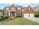 Traditional brick home with a two-car garage, blue shutters, and a well-maintained front lawn at 5870 Buckner Creek Dr, Mableton, GA 30126