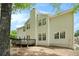Rear view of a house with a deck, large windows, light colored siding, and lush greenery at 5870 Buckner Creek Dr, Mableton, GA 30126