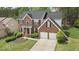 A two-story brick house with an attached two-car garage, a well-manicured lawn, and mature trees at 5870 Buckner Creek Dr, Mableton, GA 30126