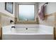 Garden bathtub with tile walls and window at 812 Nevis Way, Mcdonough, GA 30253