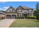 Beautiful two-story brick home with a well-manicured lawn and a three-car garage under a blue sky at 812 Nevis Way, Mcdonough, GA 30253