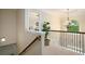 Hallway with decorative railing, view of a bedroom and modern chandelier, with light neutral paint at 812 Nevis Way, Mcdonough, GA 30253