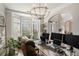 Spacious office featuring a glass desk with multiple monitors and ample natural light from the bay windows at 812 Nevis Way, Mcdonough, GA 30253