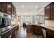 View of kitchen with wooden cabinets, stainless steel appliances, and a dining area with natural light at 812 Nevis Way, Mcdonough, GA 30253