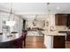 Open-concept kitchen offering island with granite counters, and views of the living and dining area at 812 Nevis Way, Mcdonough, GA 30253