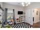Bright playroom featuring shelving and a window view, complete with checkered rug and stylish decor at 812 Nevis Way, Mcdonough, GA 30253