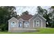 Charming single-story home with light beige stucco, arched windows, and a well-manicured lawn at 2507 Fairweather Se Ct, Conyers, GA 30013