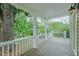 Inviting front porch with a view of mature trees, painted wood flooring, and classic white railings at 75 Meldon Se Ave, Atlanta, GA 30315