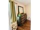 Bedroom view with a large wooden dresser, mirror, hardwood floors and bright natural light at 8 Dixie Dr, Stockbridge, GA 30281