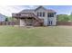 Large backyard featuring a well-maintained lawn, deck, covered patio, and fenced perimeter for privacy at 1625 Brisbane Dr, Dacula, GA 30019