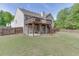 Spacious backyard with lush green grass, privacy fence, deck and patio area with stairs connecting the two at 1625 Brisbane Dr, Dacula, GA 30019