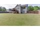 Expansive backyard with lush green grass, a wooden fence, a spacious deck, and a two-story home exterior at 1625 Brisbane Dr, Dacula, GA 30019