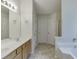 Bright bathroom featuring double sinks, wood cabinets, and multiple doorways at 1625 Brisbane Dr, Dacula, GA 30019