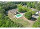 Aerial view of neighborhood amenities: a community pool, tennis courts, and playground with lush, mature trees at 1625 Brisbane Dr, Dacula, GA 30019
