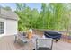 Relaxing deck area with a table, chairs, and barbecue grill perfect for entertaining or enjoying outdoor meals at 1625 Brisbane Dr, Dacula, GA 30019