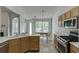 Bright kitchen features stainless steel appliances, wooden cabinets, and a dining area with natural light at 1625 Brisbane Dr, Dacula, GA 30019