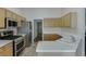 Modern kitchen featuring stainless steel appliances, light-colored cabinets, and stone tile flooring at 1625 Brisbane Dr, Dacula, GA 30019