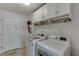 This laundry room is equipped with a washer, dryer, and overhead cabinets at 1625 Brisbane Dr, Dacula, GA 30019