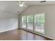 Bright living room featuring hardwood floors, three large windows, and a modern ceiling fan at 1625 Brisbane Dr, Dacula, GA 30019