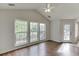 Bright living room featuring hardwood floors, three large windows, and a modern ceiling fan at 1625 Brisbane Dr, Dacula, GA 30019