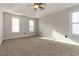 Bright main bedroom boasts natural light, plush carpeting, and a modern ceiling fan at 1650 Berryhill Rd, Cumming, GA 30041