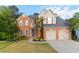 Traditional two-story brick home with a well-manicured lawn and attached two-car garage at 1650 Berryhill Rd, Cumming, GA 30041