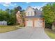 Brick home with an attached garage and a long driveway; lush landscaping and a blue sky at 1650 Berryhill Rd, Cumming, GA 30041