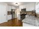 Well-lit kitchen features stainless steel appliances, granite countertops and dark wood flooring at 1650 Berryhill Rd, Cumming, GA 30041