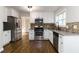 Well-lit kitchen features stainless steel appliances, granite countertops and dark wood flooring at 1650 Berryhill Rd, Cumming, GA 30041