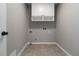 A basic laundry room with tile flooring and overhead storage at 1650 Berryhill Rd, Cumming, GA 30041