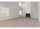 Spacious living room with a cozy fireplace, neutral carpet, and bright natural light at 1650 Berryhill Rd, Cumming, GA 30041