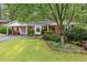 Charming brick home with a well-maintained lawn, lush landscaping and a convenient carport at 1866 Wildwood Ne Pl, Atlanta, GA 30324