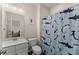 Well-lit bathroom with marble vanity and fun shark-themed shower curtain at 837 Porches Way, Dacula, GA 30019