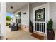 Inviting covered front porch with seating, stylish door, and manicured landscaping for relaxing curb appeal at 837 Porches Way, Dacula, GA 30019