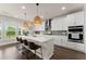 Modern kitchen features an island with seating, stainless steel appliances, and ample counter space at 837 Porches Way, Dacula, GA 30019