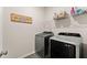 Functional laundry room featuring modern front-load washer and dryer set with storage shelf above at 837 Porches Way, Dacula, GA 30019