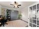 Comfortable home office space featuring built-in shelves, a Murphy bed, and a ceiling fan for versatile functionality at 837 Porches Way, Dacula, GA 30019