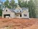 A new two-story home featuring a brick facade, attached garage, and situated on a large lot with some tree coverage in the background at 151 Tipton Ln, Acworth, GA 30102