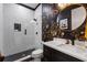 Modern bathroom showcasing herringbone tile, chic wallpaper, and sleek fixtures, offering luxurious style at 210 Locust Ne St, Atlanta, GA 30317
