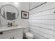 Bathroom featuring a round mirror over a single sink vanity and shower with a striped curtain at 210 Locust Ne St, Atlanta, GA 30317