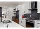Bright kitchen featuring white cabinetry, black hardware, stainless appliances, and stylish black backsplash at 210 Locust Ne St, Atlanta, GA 30317