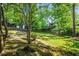 Spacious, tree-lined backyard with lawn, wooden fence, stone steps, and mature shrubs at 2977 Parkridge Ne Dr, Brookhaven, GA 30319