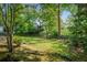 Secluded backyard with mature trees, shrubs, and a wooden fence, offering a private outdoor space at 2977 Parkridge Ne Dr, Brookhaven, GA 30319