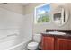 Traditional bathroom with a tub-shower combo, a vanity with dark countertops, and a decorative mirror at 7322 Bridlewood Ct, Jonesboro, GA 30236