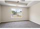 Spacious bedroom with plush carpeting, a ceiling fan, and a large window offering neighborhood views at 7322 Bridlewood Ct, Jonesboro, GA 30236