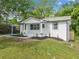 Charming white brick home featuring a carport, black trim, and a manicured front yard at 130 Oakcliff Court, Atlanta, GA 30331