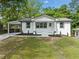 Charming white brick home featuring a carport, black trim, and a manicured front yard at 130 Oakcliff Court, Atlanta, GA 30331