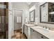 Double vanity bathroom with marble countertops, elegant mirrors, tiled floors and view to separate toilet room at 1922 Olde Village Run, Dunwoody, GA 30338