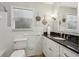 Bathroom featuring a white vanity with a dark countertop, a large mirror, and classic fixtures at 1922 Olde Village Run, Dunwoody, GA 30338